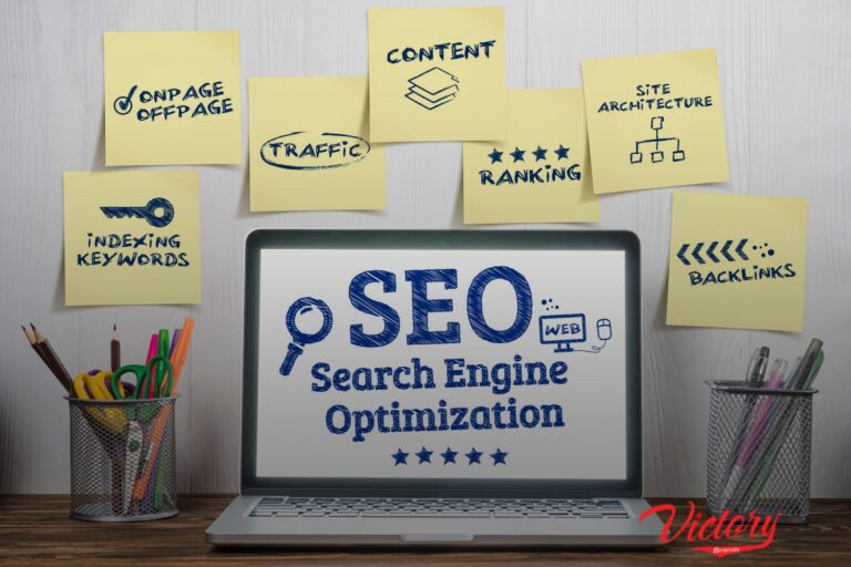 a laptop with a word "SEO Search Engine Optimization" on screen. With a lot of sticky notes in the background